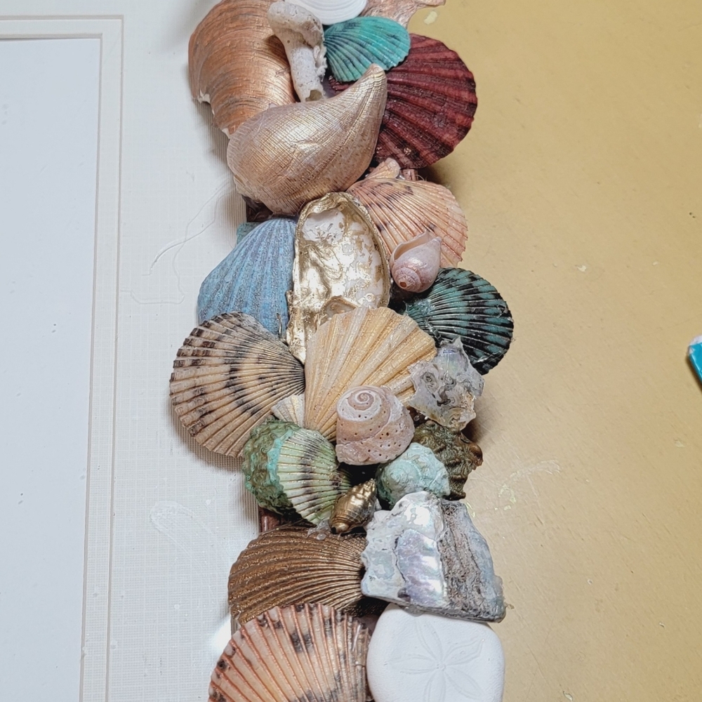Seashell embellished picture frame with lighthouse photo.